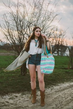 Hippi kız toprak yolda ayakta. Indie