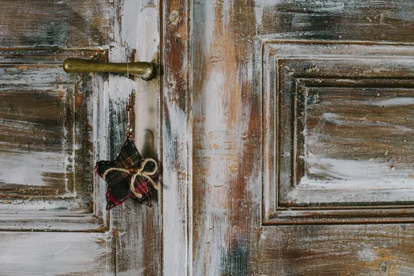 Decorative christmas star hanging on the old door handle — Stock Photo, Image
