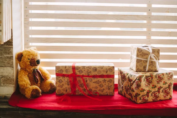 Teddy bear, with gifts on the window sill — Stock Photo, Image