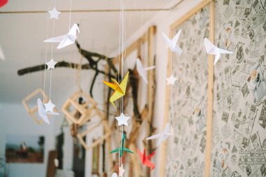 Sarı Origami sinekkuşları iplikler üzerinde asılı.