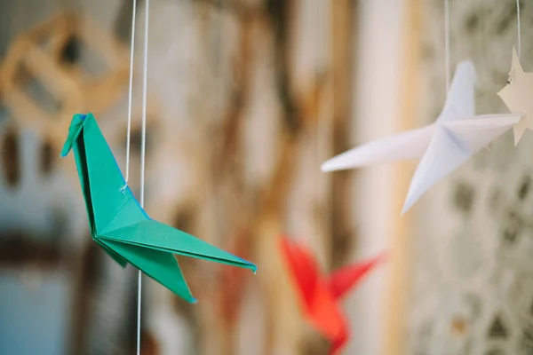 Green Origami hummingbirds are hanging on threads — Stock Photo, Image