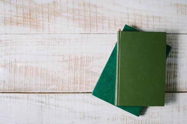 Green books lie on a wooden table. top view — Stock Photo, Image