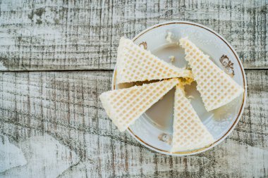 Eski bir tabakta waffle keki, ahşap masa, üst manzara.