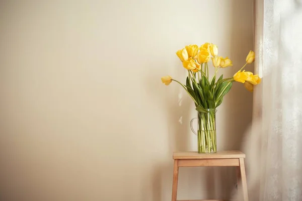 ホームインテリアデザイン 木製のスツールに黄色のチューリップの花束 — ストック写真