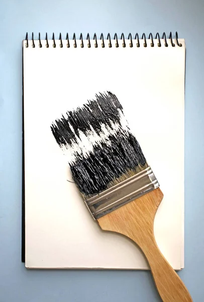 Open Notebook Brush Blue Background Black Paint — Stock Photo, Image