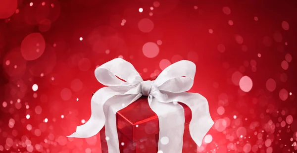 Presente Natal Contra Luzes Bokeh Vermelho Fundo — Fotografia de Stock