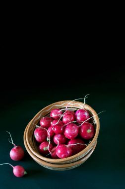 Karanlık bir arka plan üzerine bir kase içinde turp.