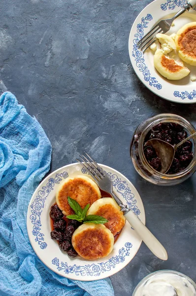 Süzme peynir tabakta vişne reçelli krep ve nane yaprağı ile dekore edilmiş.