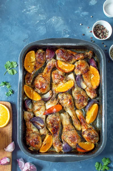 Portakal ve kırmızı soğan ile pişmiş tavuk parçaları.