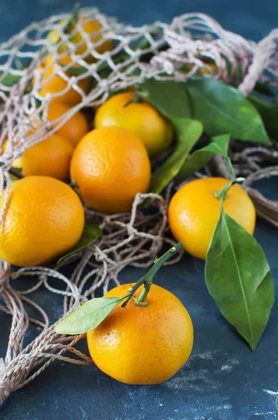 Mandalina yaprakları yakın çekim bir çanta kılavuzda mavi bir arka plan ile. Yatay fotoğraf.