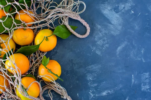 angerines ile mavi bir arka plan bir çanta kılavuzda yakın çekim yaprak. Yatay fotoğraf.