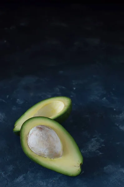 Arka plan arka plan üzerinde avokado yarım. Dikey fotoğraf.