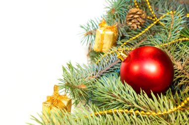 Noel ağacı dalları koniler, hediyeler ve oyuncaklar üzerinde beyaz bir ba