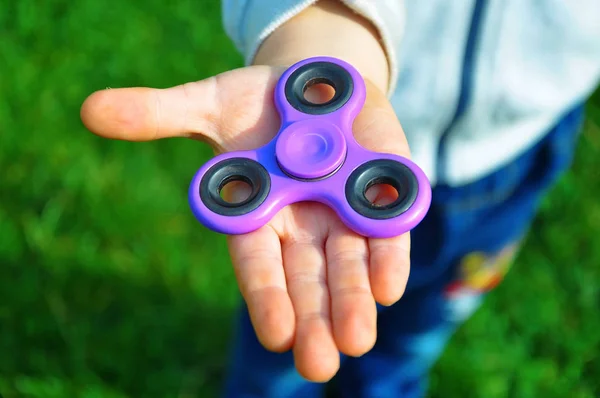 Kind hält den Spinner in der Hand — Stockfoto