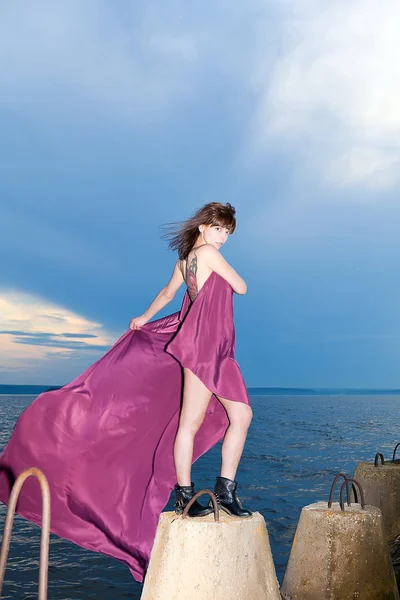 Brünette im kastanienbraunen Kleid am Ufer des Flusses — Stockfoto