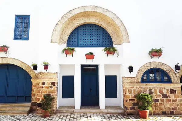 Pátio oriental tunisino casas com paredes brancas e portas de janelas azuis — Fotografia de Stock