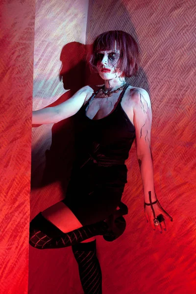 Zombie chica en vestido negro en la luz roja — Foto de Stock