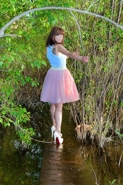 Girl in summer dress surrounded by greenery running along water — Stock Photo, Image