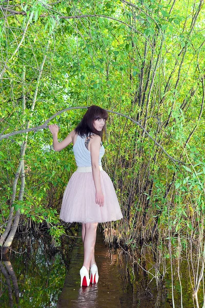 Girl in summer dress surrounded by greenery running along water — Stock Photo, Image