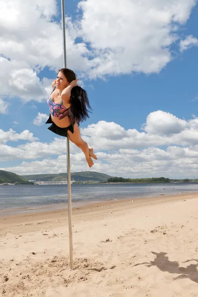 Tänzerin an Stange führt Akrobatik auf — Stockfoto