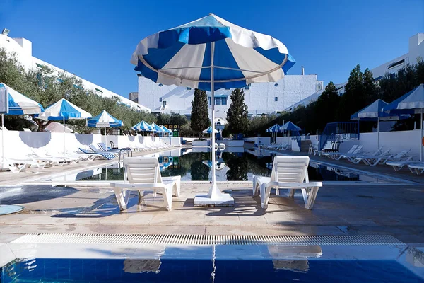 Openbaar zwembad met ligbedden en parasols blauw — Stockfoto