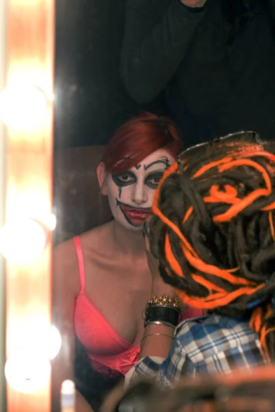 actress put on makeup clown in front dressing room mirror