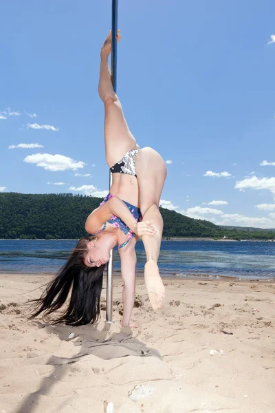 Dancer on pole performs acrobatic — Stock Photo, Image