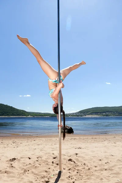 Tänzerin an Stange führt Akrobatik auf — Stockfoto