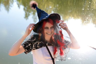 Nehri yakınında sivri siyah şapkalı genç cadı