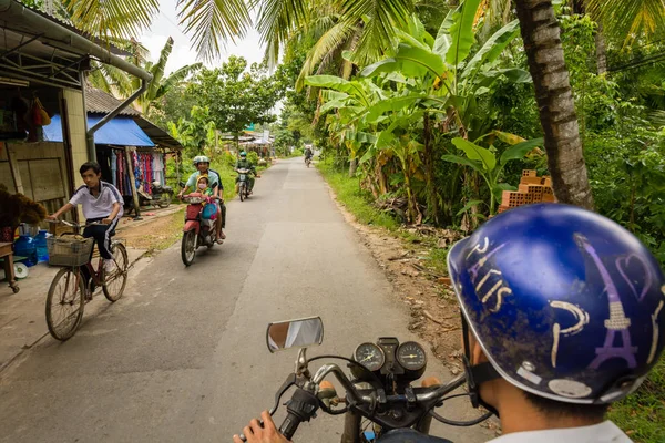 Motorista montando sua scooter na movimentada estrada rural em Nhon Thanh villa — Fotografia de Stock