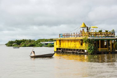 Onun küçük tekne yüzen köyde Tonle SA'da kullanan genç kadın