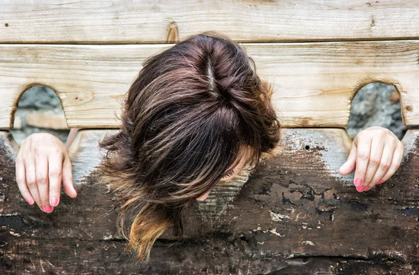 Young caucasian woman in medieval pillory, punishment device — Stock Photo, Image