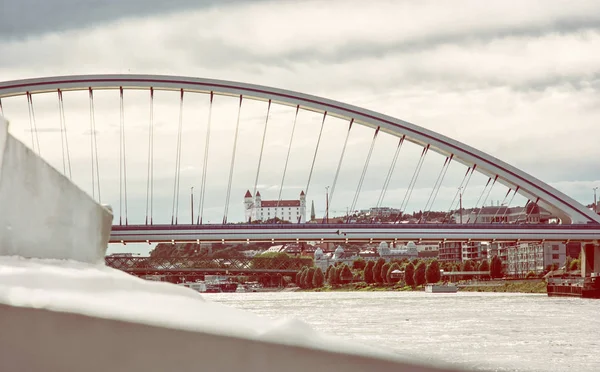 Bratislava castle behind modern Apollo bridge, retro photo — Stock Photo, Image