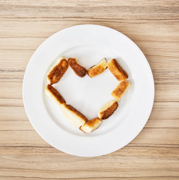 Valentine's heart made of sweet scones on white plate — Stock Photo, Image