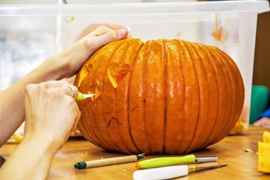 Jack-o-lantern bıçakla kesen kadınların elleri, yakın çekim