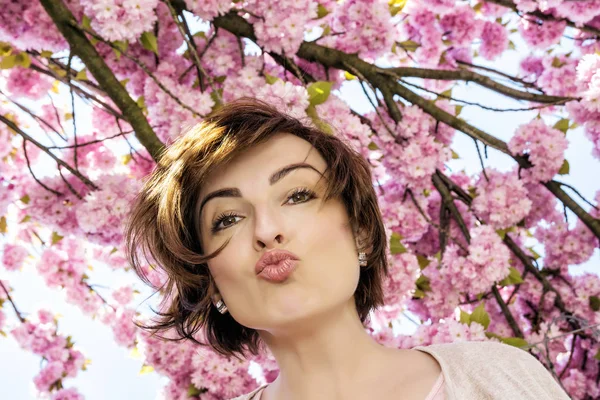 Mujer joven con flores de sakura —  Fotos de Stock