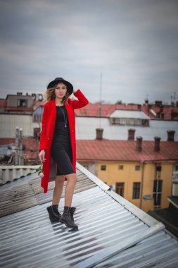 Kız kırmızı ve siyah şapkalı eski şehir çatıda poz