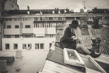 Kız kırmızı ve siyah şapkalı eski şehir çatıda poz