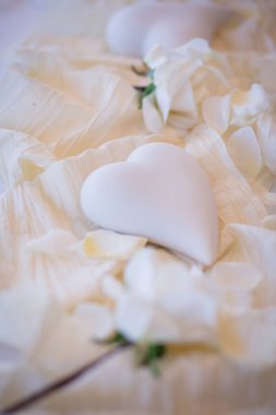 Beyaz kalp beyaz gül yaprakları ile masada. Düğün töreni