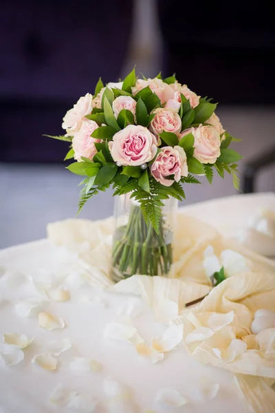Wedding bouquet from pink roses with green on the table. Marriage ceremony — Free Stock Photo