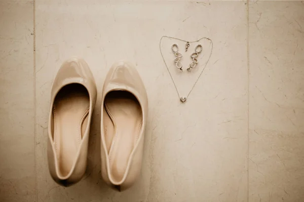 Accesorii pentru mireasă în ziua nunții. Lanțul arată ca inima și pantofii — Fotografie, imagine de stoc