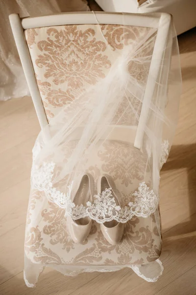 Scarpe da sposa con tacco alto per un felice matrimonio sotto il velo sulla sedia — Foto Stock