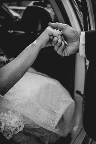 Novio dar las manos novia fuera del coche de la boda. Blanco y negro — Foto de Stock