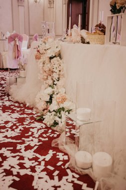 Restoranda düğün çiçekleri süslemesi. Çiçek buketleri ve cam tüplerle süslenmiş düğün çiftleri için masalar.