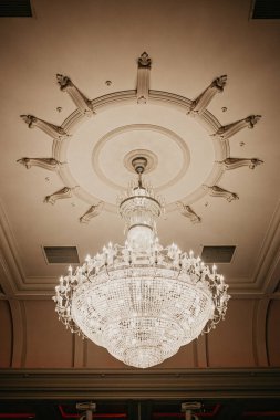 Kristal avize yakın plan. Düğün resepsiyonu için çadırın altında güzel bir ziyafet salonu. Bir düğün çadırının içi. Konuklar için dekorasyon hazır.