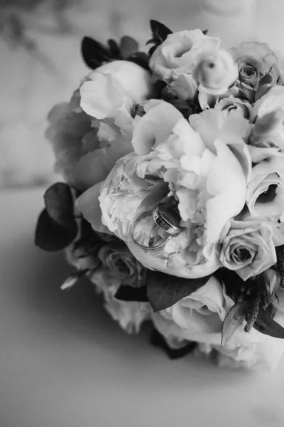 2 golden rings on wedding bouquet with beautiful roses and pions. Wedding day. Wedding preparation. Monochrome. Black and white — Stock Photo, Image