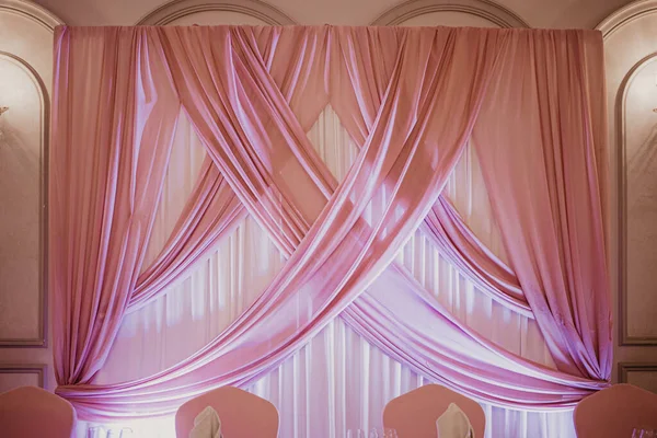 Decoración rosa de boda en el restaurante. Pared de tela rosa sobre la mesa de matrimonio — Foto de Stock
