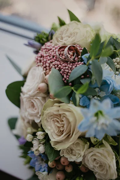 2 anillos de oro en el ramo de bodas con hermosas rosas. Día de la boda. Preparación de boda — Foto de Stock