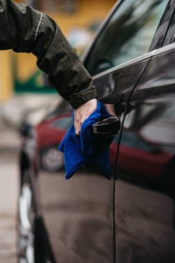 Kahverengi arabanın el dezenfekte edici kapı kolu mavi dezenfektan mendille. Virüsü ve bakterileri önle, kovid19 'u önle, korona virüsü, alkol dezenfektanı. Evde hijyen kavramı.