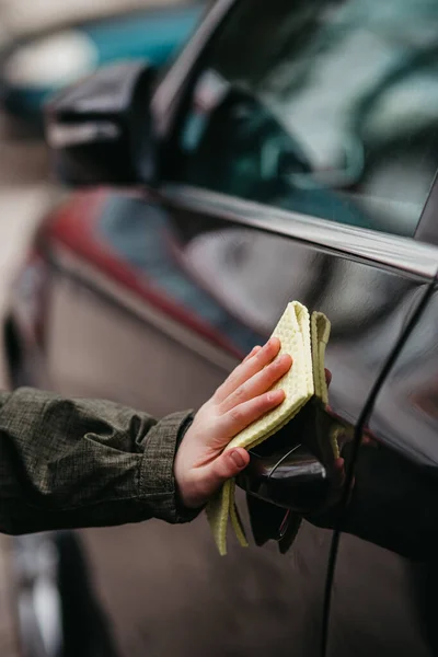 Sarı dezenfektanla dezenfekte edilen kahverengi arabanın kapı kolu. Virüsü ve bakterileri önle, kovid19 'u önle, korona virüsü, alkol dezenfektanı. Evde hijyen kavramı.